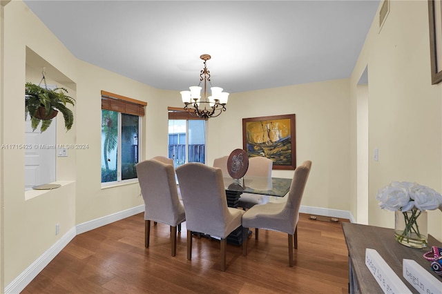 dining room with hardwood / wood-style floors and an inviting chandelier