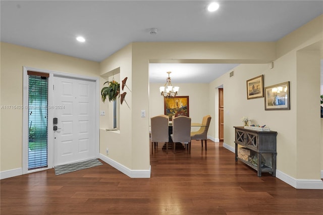 foyer entrance with dark hardwood / wood-style floors and an inviting chandelier