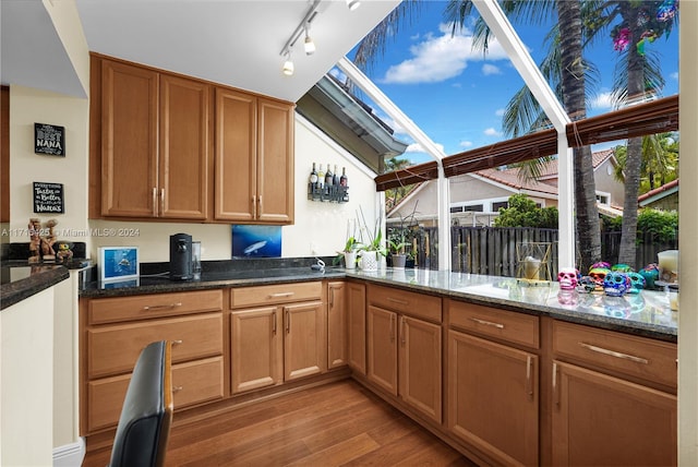 kitchen with dark stone countertops, plenty of natural light, a skylight, and light wood-type flooring