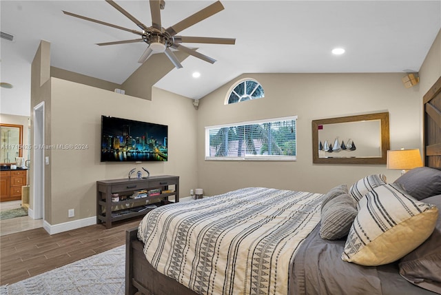 bedroom with ceiling fan, connected bathroom, and vaulted ceiling