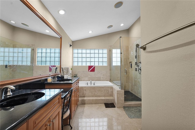 bathroom featuring vanity, independent shower and bath, and lofted ceiling