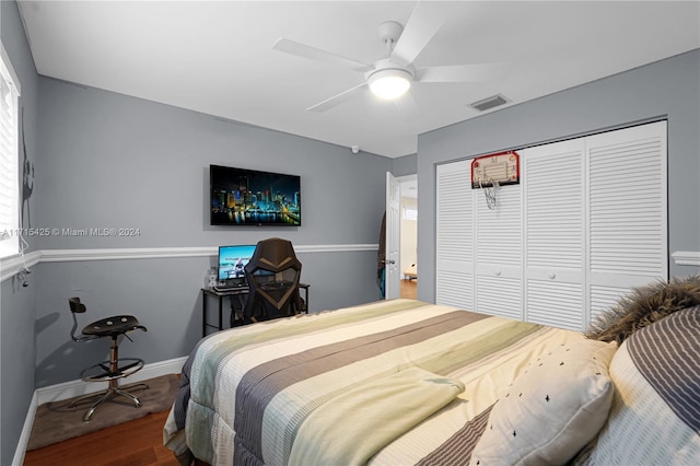 bedroom with hardwood / wood-style floors, a closet, and ceiling fan