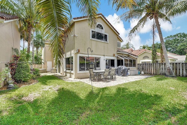 back of property featuring a lawn and a patio area