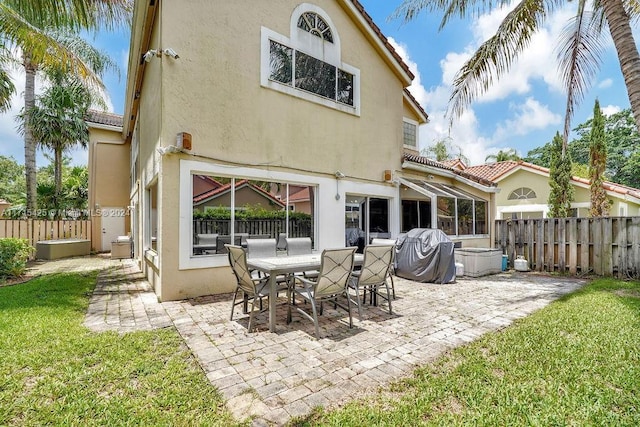 rear view of property with a lawn and a patio area