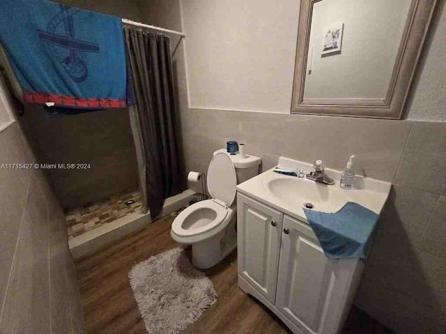 bathroom with wood-type flooring, vanity, toilet, and curtained shower