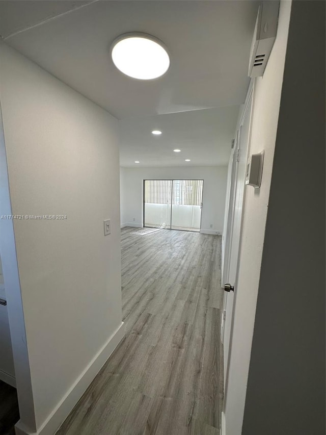 corridor featuring a wall mounted air conditioner and light hardwood / wood-style flooring