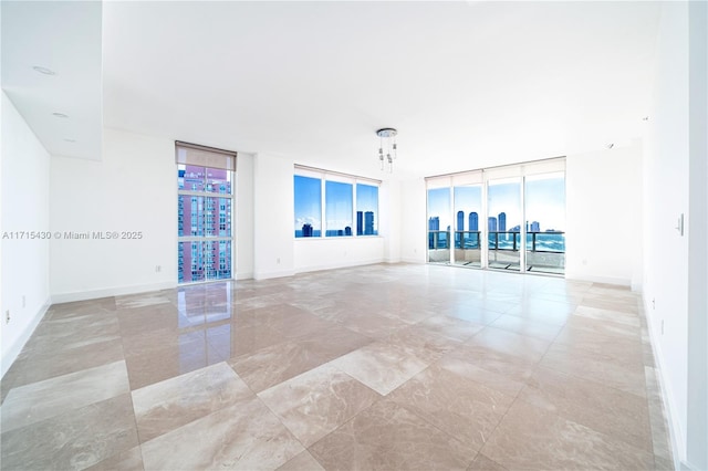 living area with baseboards and floor to ceiling windows