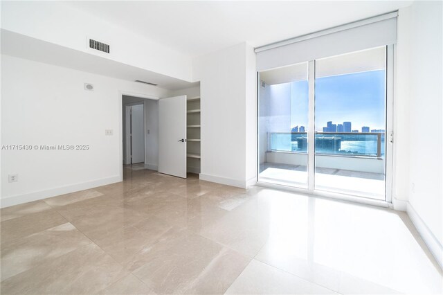 unfurnished bedroom featuring expansive windows, a closet, and multiple windows