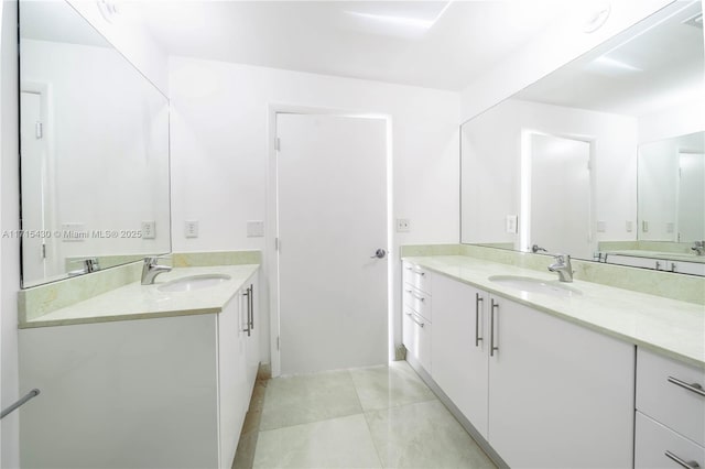 full bath featuring two vanities, a sink, and tile patterned floors