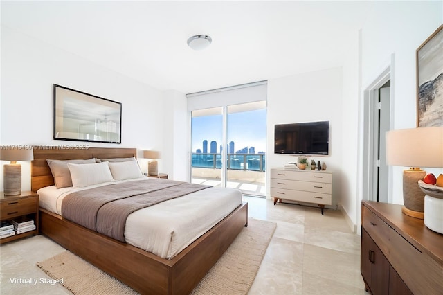 bedroom featuring access to outside, baseboards, and a wall of windows