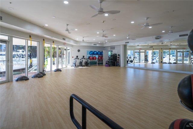 gym with light wood-type flooring and french doors