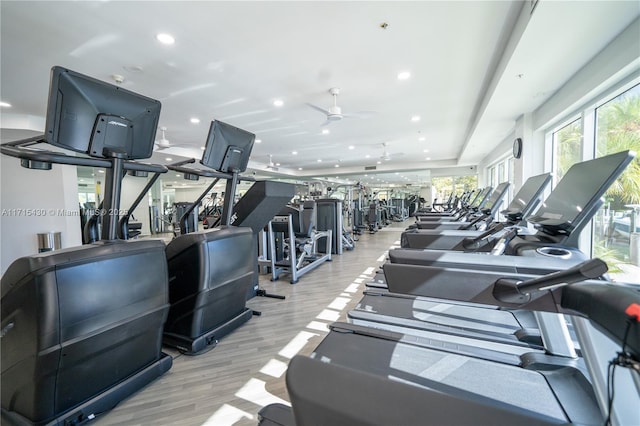 gym with light wood-style floors, a ceiling fan, and recessed lighting