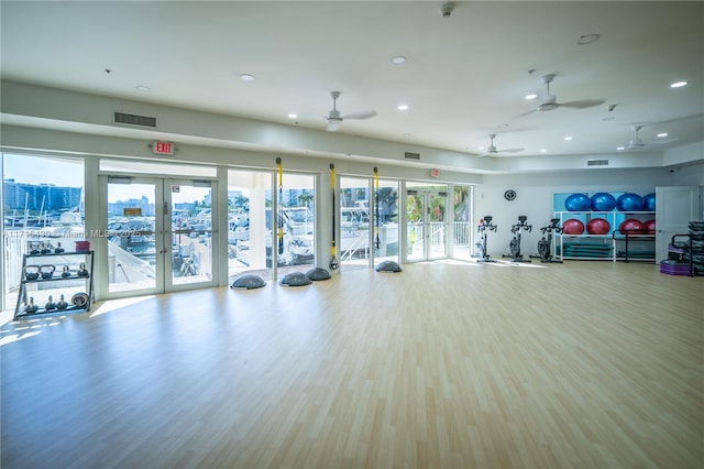 gym featuring ceiling fan, french doors, and light hardwood / wood-style flooring