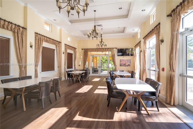 dining area with a high ceiling, hardwood / wood-style floors, french doors, a notable chandelier, and crown molding