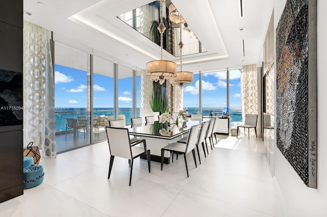 tiled dining room with a water view and a wall of windows