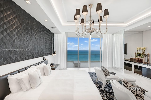 bedroom with a tray ceiling, access to exterior, and an inviting chandelier