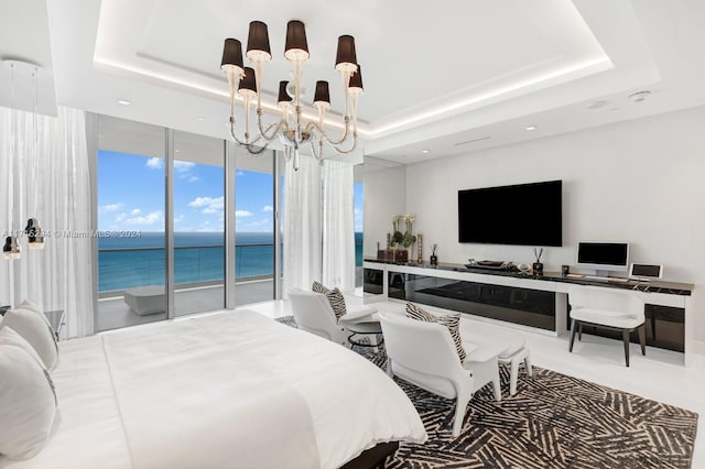 bedroom with access to outside, a raised ceiling, expansive windows, and a notable chandelier