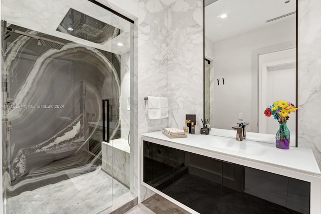 bathroom with vanity, an enclosed shower, and tile walls