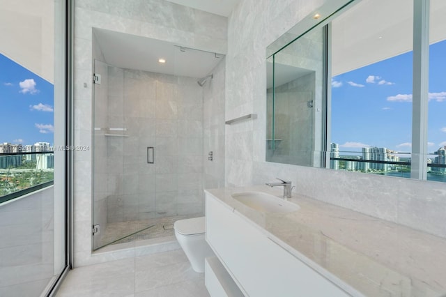 bathroom with tile patterned floors, vanity, a shower with shower door, and toilet