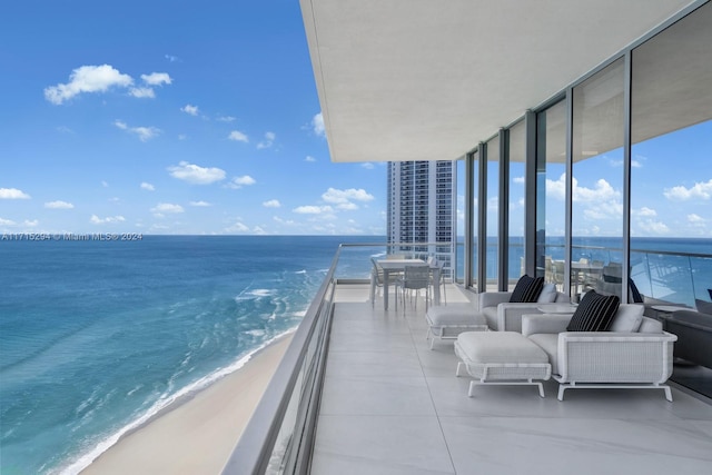 balcony featuring a water view and a beach view