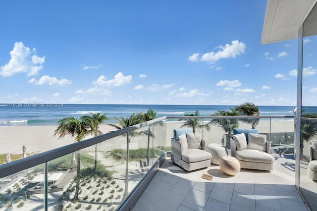 balcony featuring a water view and a beach view