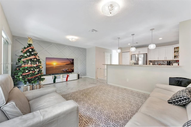 living room with an accent wall, baseboards, visible vents, and marble finish floor