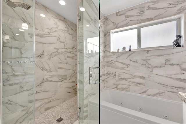 bathroom with a marble finish shower, a tub with jets, and recessed lighting