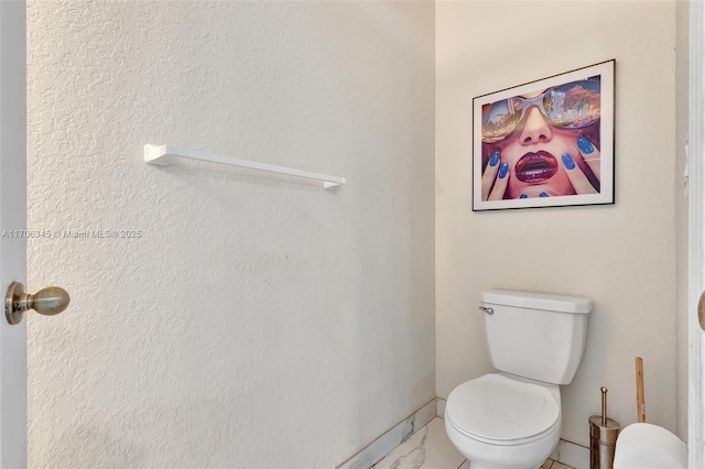 bathroom featuring baseboards and toilet