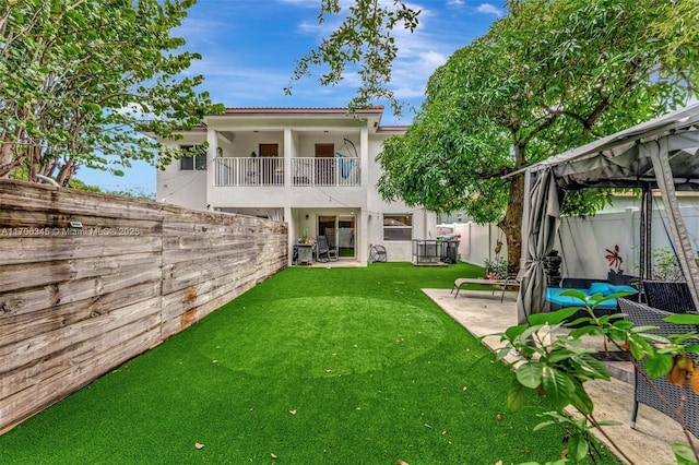 back of house featuring stucco siding, a fenced backyard, a gazebo, a balcony, and a patio area