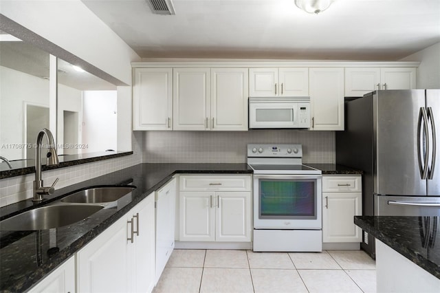 kitchen featuring sink, tasteful backsplash, dark stone countertops, white appliances, and white cabinets