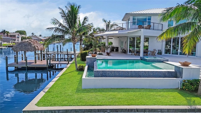 view of swimming pool with an in ground hot tub, a water view, a yard, and a patio