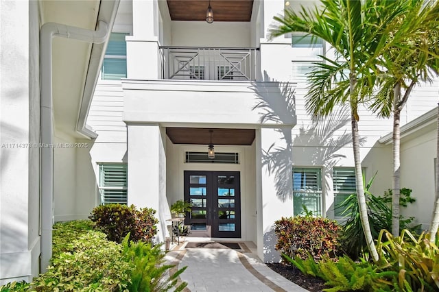 entrance to property featuring a balcony and french doors