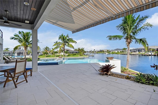 view of pool with a water view, ceiling fan, and a patio area