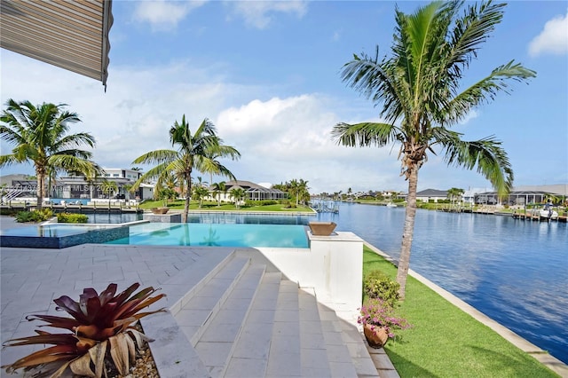 view of swimming pool featuring a water view, a hot tub, and a patio area