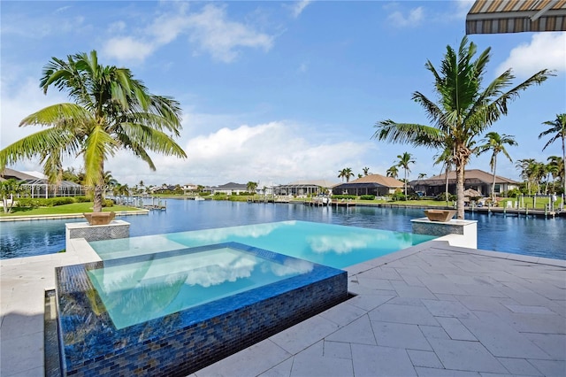 view of swimming pool with an in ground hot tub and a water view