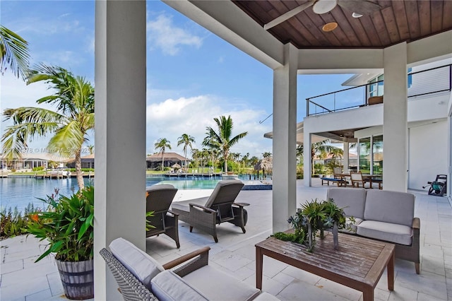 view of patio featuring an outdoor hangout area, a balcony, ceiling fan, and a water view