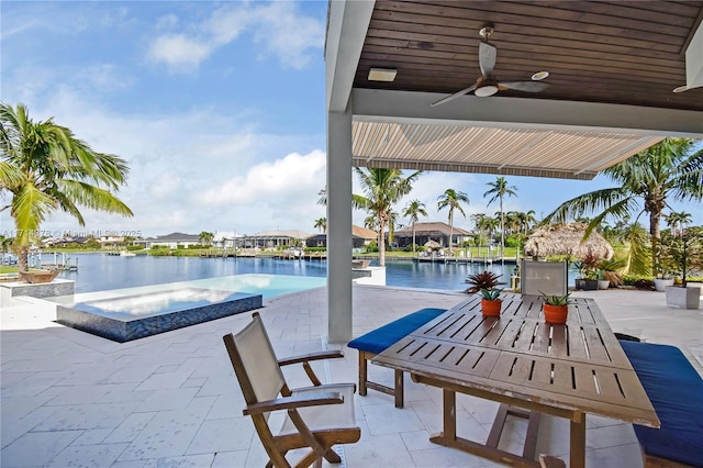 view of pool with a patio area, an in ground hot tub, ceiling fan, and a water view