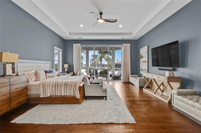 bedroom with a raised ceiling, ceiling fan, access to outside, and dark hardwood / wood-style flooring