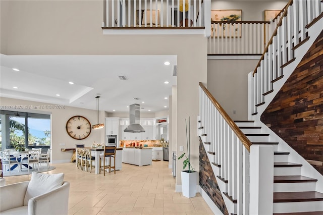 stairway featuring a towering ceiling