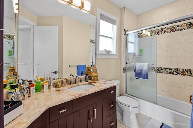 full bathroom featuring vanity, bath / shower combo with glass door, and toilet