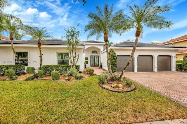 view of front of property with a front yard and a garage