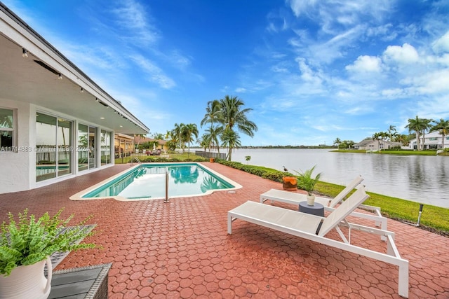 view of swimming pool with a patio area and a water view