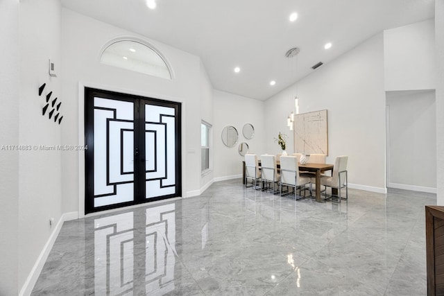 dining area featuring french doors and a high ceiling