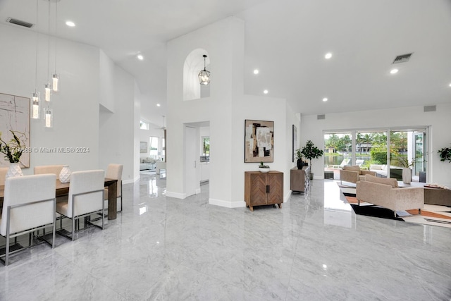 living room featuring a towering ceiling and a notable chandelier