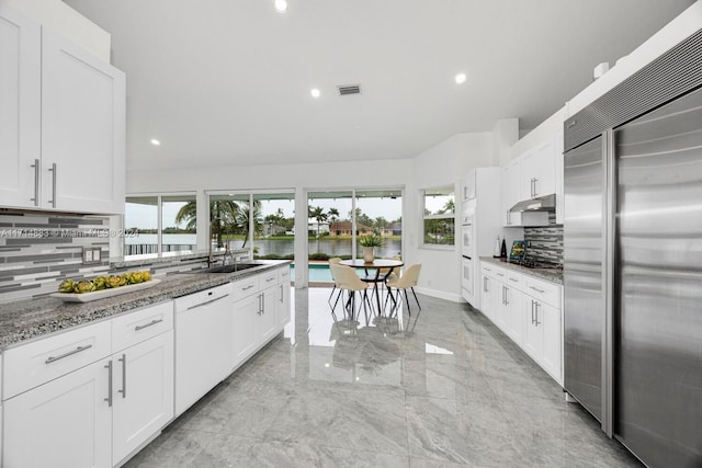 kitchen featuring light stone countertops, white dishwasher, white cabinets, and built in fridge