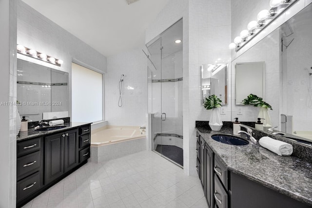 bathroom featuring tile patterned flooring, vanity, tile walls, and shower with separate bathtub