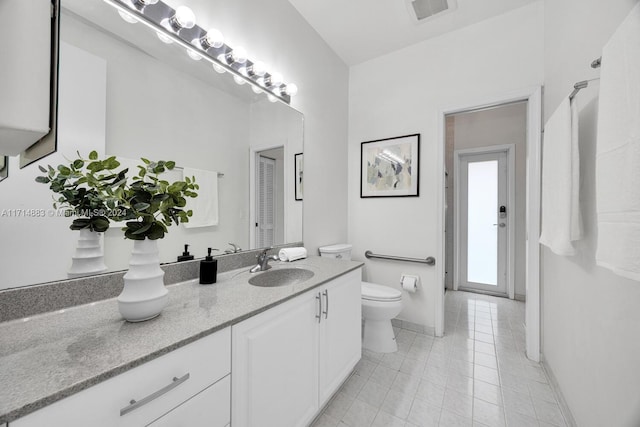 bathroom featuring tile patterned floors, vanity, and toilet