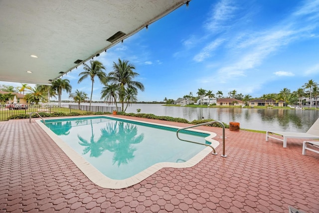 view of swimming pool featuring a water view and a patio