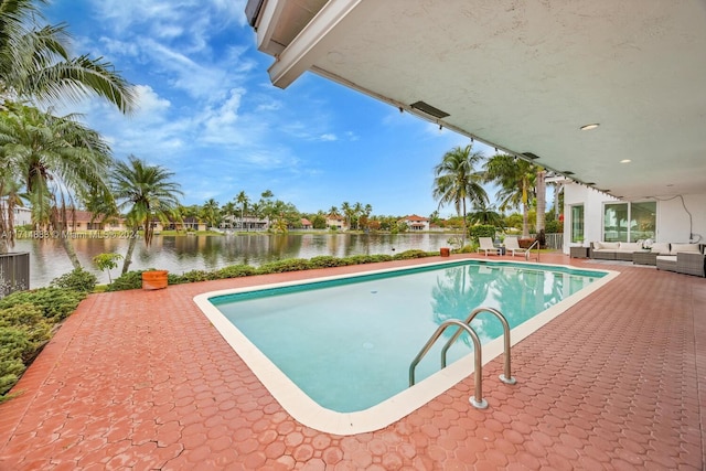 view of pool featuring a patio area, a water view, and an outdoor hangout area