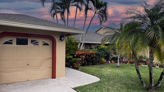 garage at dusk with a lawn